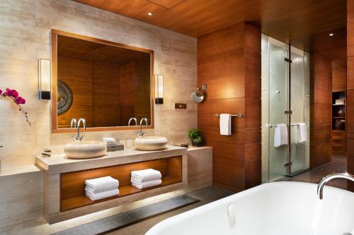 a bathroom with two sinks and a large mirror at Raffles Hainan Clear Water Bay in Sanya