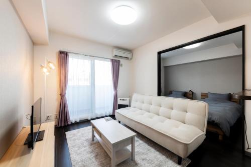 a living room with a couch and a large mirror at STARGAZE in Ōdōri