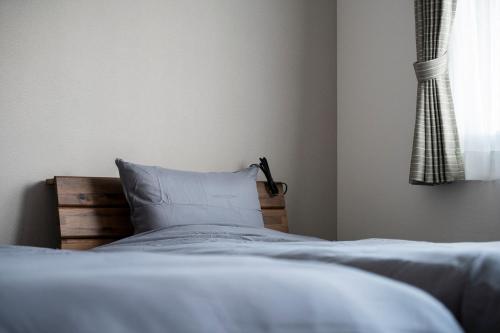 a bedroom with a bed with a pillow and a window at STARGAZE in Ōdōri