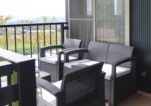 a porch with chairs and a balcony with a view at Tsugumori つぐもりステイ in Komoro