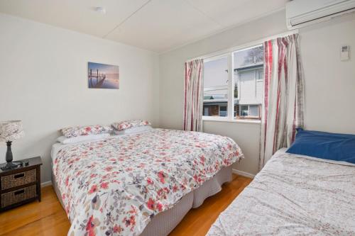 a bedroom with a bed and a window at Authentic Kiwi Lodge by the Lake in Rotorua