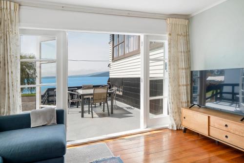 a living room with a large sliding glass door at Authentic Kiwi Lodge by the Lake in Rotorua