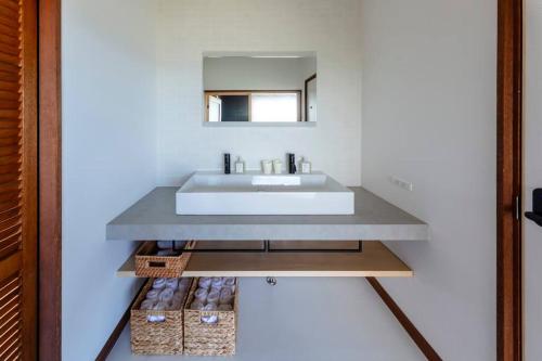 a bathroom with a sink and a mirror at The Villas atami amazing ocean view in Taga