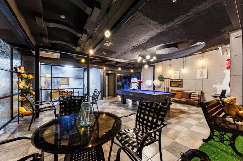 a room with a ping pong table and chairs at Seosan No25 Hotel in Seosan