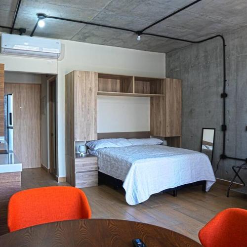 a bedroom with a bed and two orange chairs at Prime Monterrey Stay 4 in Monterrey