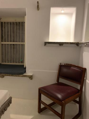 a chair sitting in a room with a bedroom at Peacock Guest House - Lake View Hotel In Udaipur in Udaipur