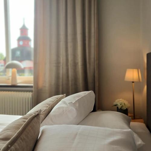 a bedroom with a bed with pillows and a window at Hotell Rådhuset in Lidköping