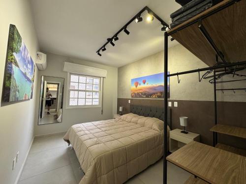 een slaapkamer met een bed en een poster aan de muur bij Apartamento Gonzaga Conforto in Santos