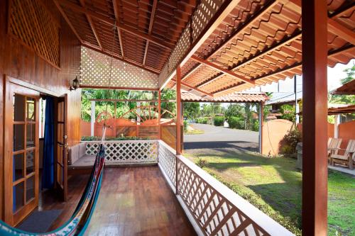 a porch of a house with a hammock on it at Pangea Lodge with Shared Pool at the Heart of Manzanillo in Manzanillo