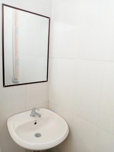 a bathroom with a white sink and a mirror at Musafira Hotel Syariah in Sentool