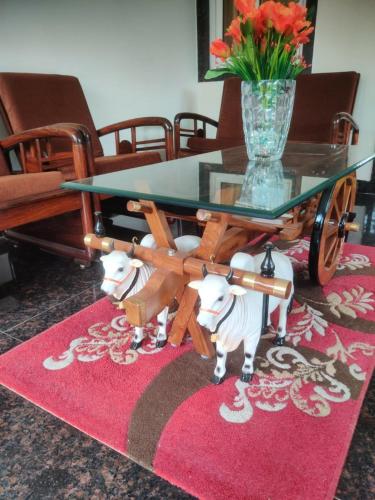 a glass table with two dogs on a red rug at Siva Rama garden resort & swimming pool 5star stay comfort 6BHK bheemili beach road nr in Visakhapatnam