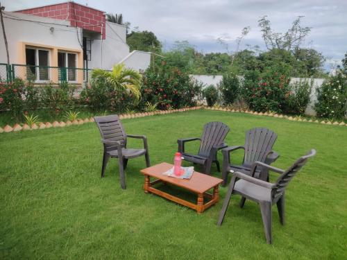 a group of chairs and a table on a lawn at Siva Rama garden resort & swimming pool 5star stay comfort 6BHK bheemili beach road nr in Visakhapatnam