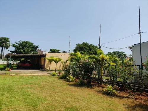 a yard with a fence and a house at Siva Rama garden resort & swimming pool 5star stay comfort 6BHK bheemili beach road nr in Visakhapatnam