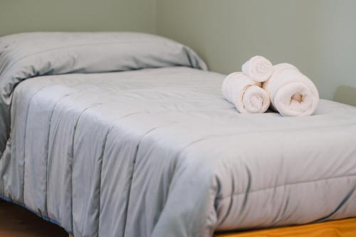 a bed with three rolled up towels on it at Butera 505-Luxury Suites in Bagheria