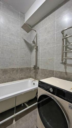 łazienka z wanną i pralką w obiekcie Квартира w mieście Yalanghoch