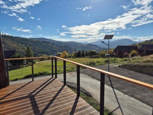 a wooden deck with a view of mountains at Bacmańska Chata z pięknym widokiem przy szlaku jacuzzi Beskidy in Złatna