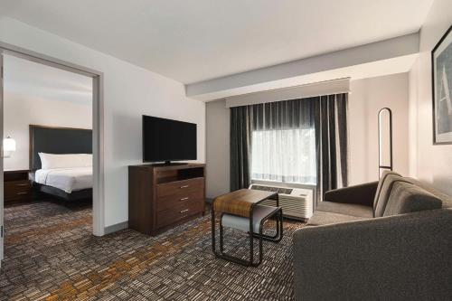 a hotel room with a bed and a television at Homewood Suites by Hilton - Charlottesville in Charlottesville