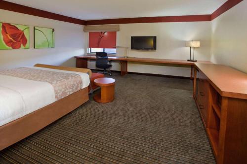 a hotel room with a bed and a desk at Travelodge by Wyndham Columbus State University in Columbus