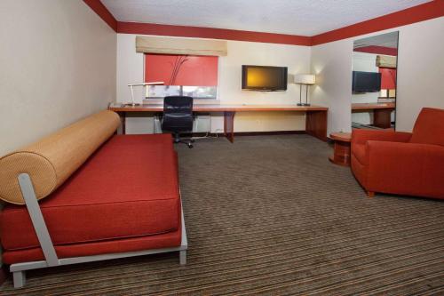 a hotel room with a bed and a desk at Travelodge by Wyndham Columbus State University in Columbus