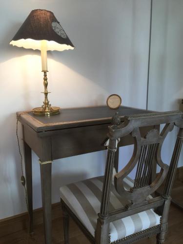a desk with a lamp and a chair at Les Prémices De La Forêt in Chailly-en-Bière