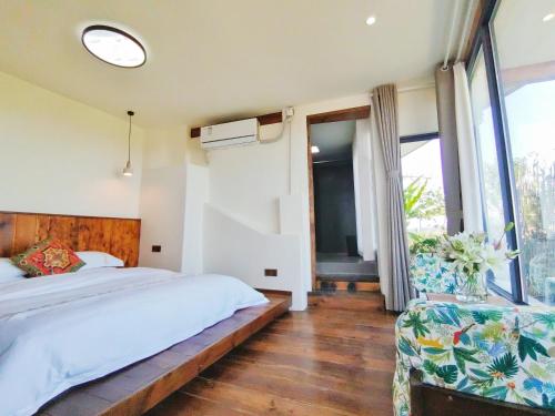 a bedroom with a bed and a large window at 张家界东篱山居民宿- Free pick up service in Zhangjiajie
