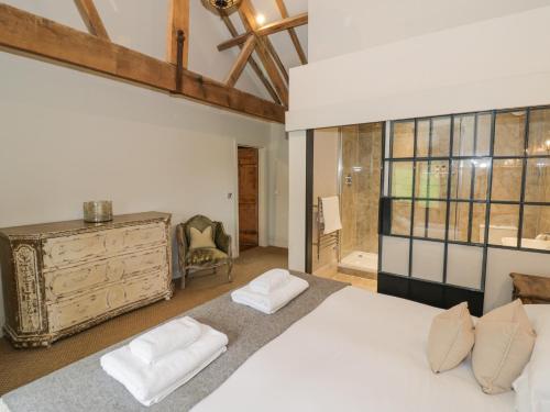 Un dormitorio con una gran cama blanca y una ventana. en The Stables, en Ledbury