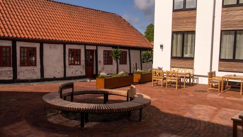 a patio with a bench and a table and a building at Hotel Skivehus in Skive