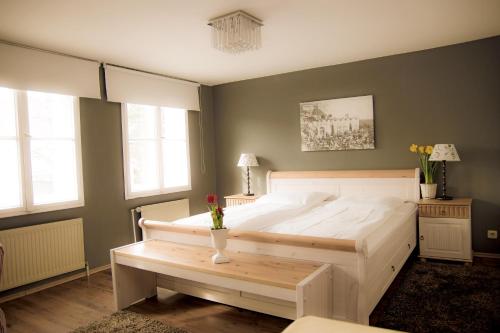 a bedroom with a large white bed and a table at Gasthof Rabenwirt in Pullach im Isartal
