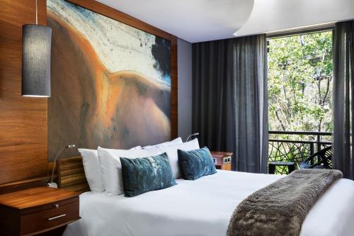 a hotel room with a bed and a large window at Seven Villa Hotel & Spa in Johannesburg