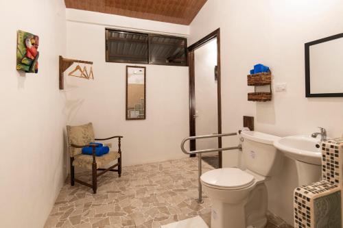 a bathroom with a toilet and a sink at Pangea Lodge with Shared Pool at the Heart of Manzanillo in Manzanillo