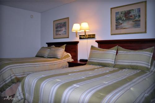 a hotel room with two beds and two lamps at Gladstone Inn and Suites in Jamestown
