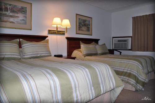 a hotel room with two beds and two lamps at Gladstone Inn and Suites in Jamestown