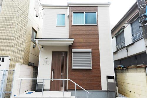 a building with a brown door in front of it at NYHotel 3 新宿2階建て3室1バスルーム1シャワー2トイレ in Tokyo