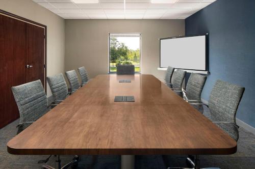 a conference room with a large wooden table and chairs at Hampton Inn Ft Wayne in Fort Wayne