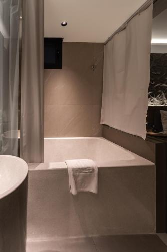 a bathroom with a bath tub with a towel on it at Kin Hotel Thai Van Lung in Ho Chi Minh City