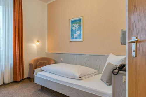 a bedroom with a bed with a picture on the wall at Sautter Hotel Stuttgart City in Stuttgart
