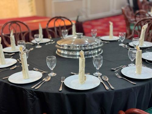 a table with plates and silverware on a black table cloth at ROYAL PARK HOTEL @ UNITEN in Kajang
