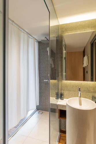 a bathroom with a sink and a shower at Kin Hotel Thai Van Lung in Ho Chi Minh City