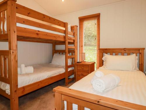 a bedroom with two bunk beds and a window at 1 Hedgerows in Looe
