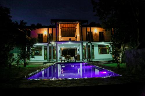 a house with a swimming pool at night at Prana Ayurveda Yoga Center in Balapitiya
