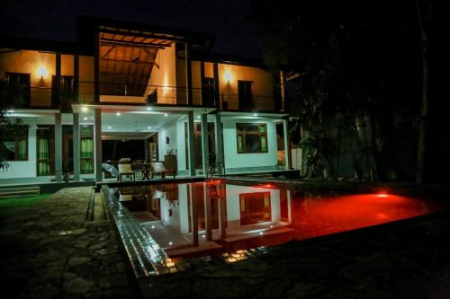 a house at night with a pool in front of it at Prana Ayurveda Yoga Center in Balapitiya