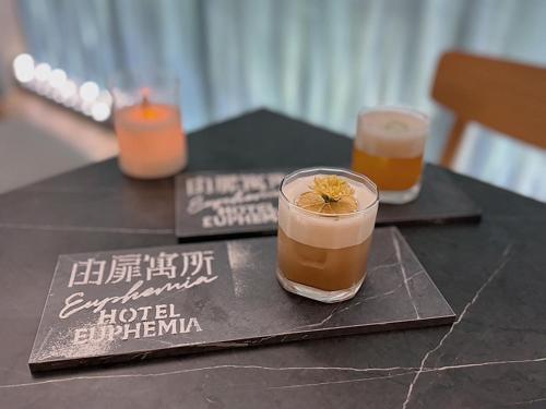 a black table with two drinks and two candles at Hotel Euphemia in Taichung