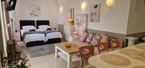 a bedroom with a bed and a table and chairs at Carla Apartment Opuzen Modern Oasis and Comfort in Opuzen