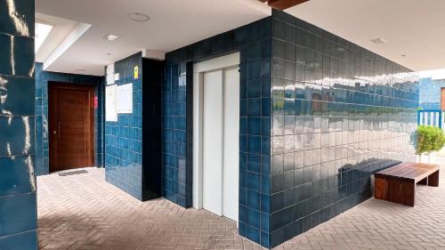 a blue tiled wall with a bench and a door at Turquesa del Mar - Charming Ground-Floor Spanish Apartment with Large Sunny Terrace in Orihuela Costa