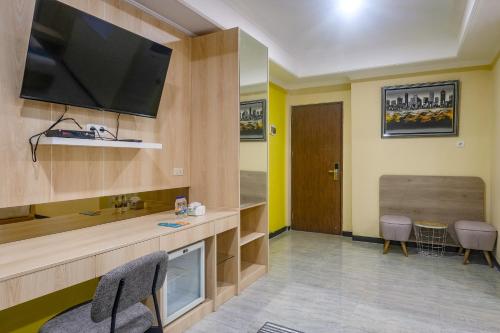 a room with a flat screen tv on a wall at Sans Hotel City Park Medoho Semarang in Alastuwo