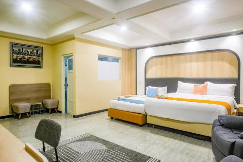a hotel room with a bed and a couch at Sans Hotel City Park Medoho Semarang in Alastuwo