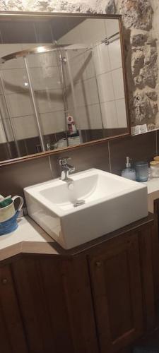 a white bathroom sink with a large mirror at Kallistws House in Zigovístion