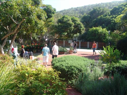 a group of people walking around a garden at Serendipity Country House & Restaurant in Wilderness