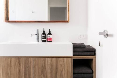 une salle de bain avec un lavabo et un miroir dans l'établissement Casa Del Mar 6 - Walk to Pottsville Beach!, à Pottsville