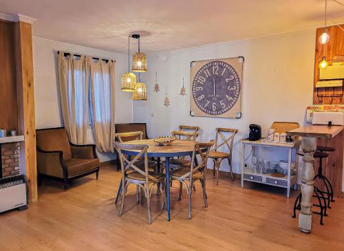a dining room with a table and chairs and a clock at Hotel Hita "Nature Experience" for all in Navacerrada